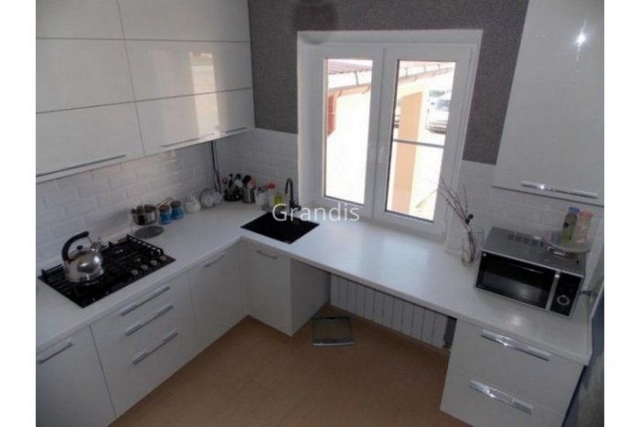 Угловая кухня со столешницей под окном