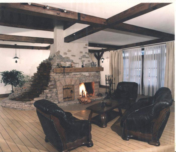 Камин из камня в центре гостиной