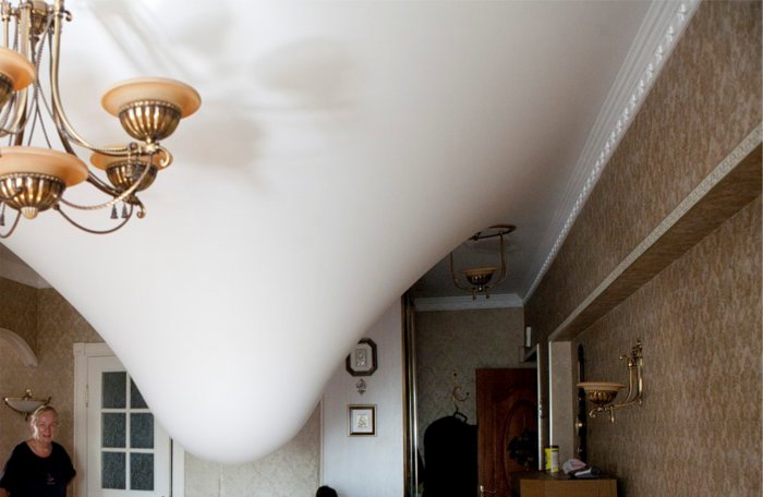 Слить воду с натяжного потолка